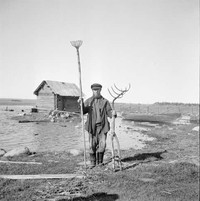 Рис. 10. Мужчина с рыболовными снастями, предназначенными для лучения рыбы (https://www.sotasampo.fi/ Рейно Пелтола). Заонежье